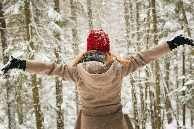 Woman Standing In Snow Wearing Brown Coat