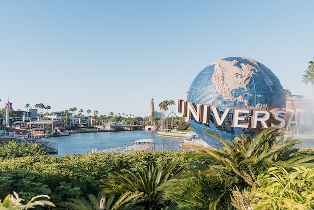 Universal studio globe next to a body of water and palms