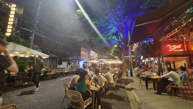 Busy pedestrian street in Colombia at night with party-goers